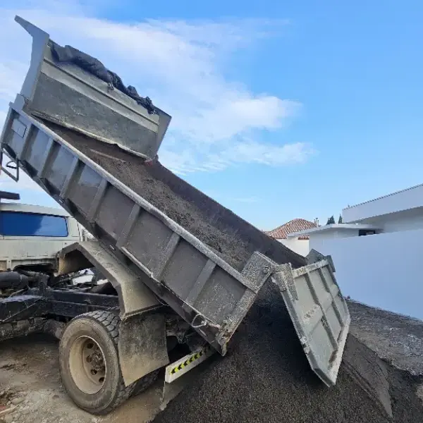 Camión tolva descargando áridos en una obra de Chicureo